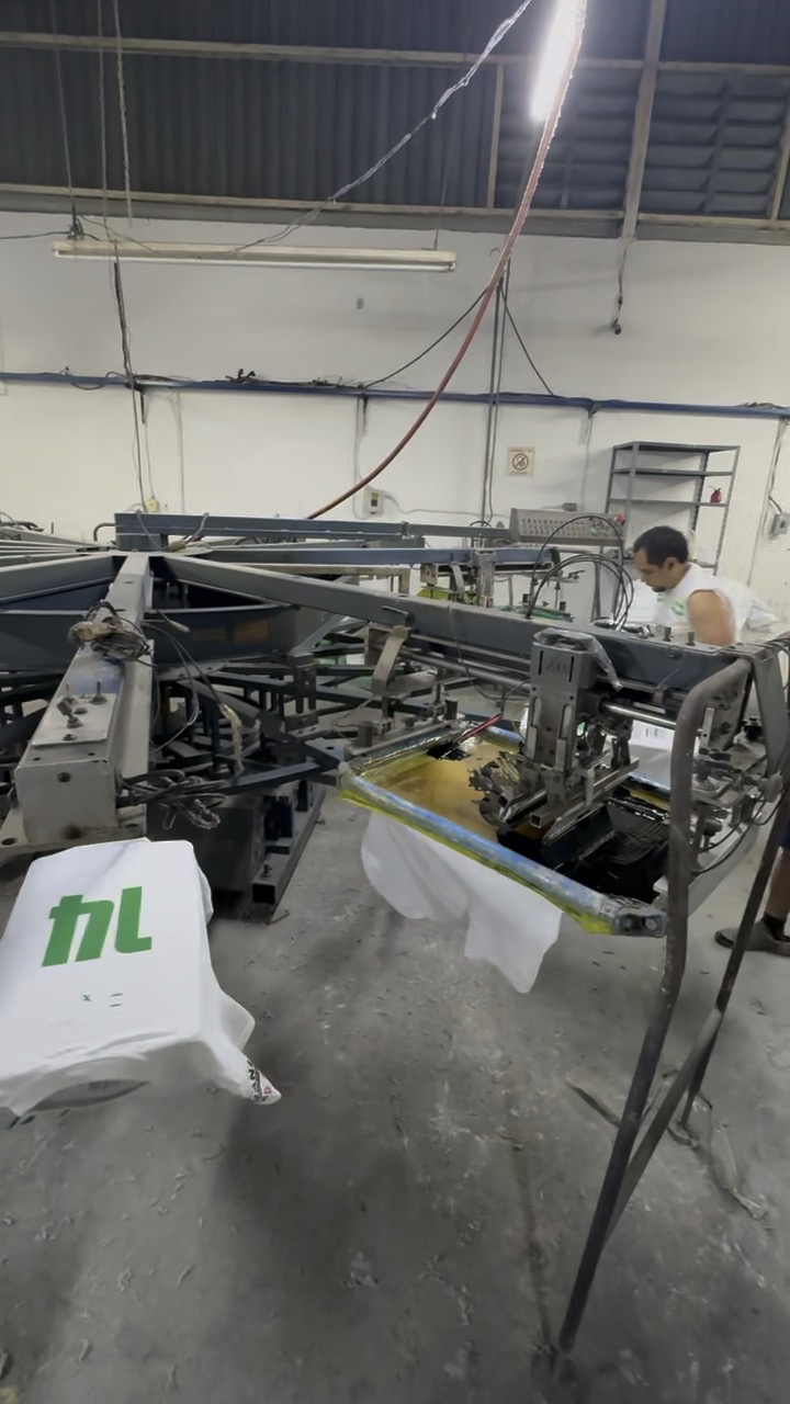 Playera blanca montada en el pulpo durante la impresión de tinta verde